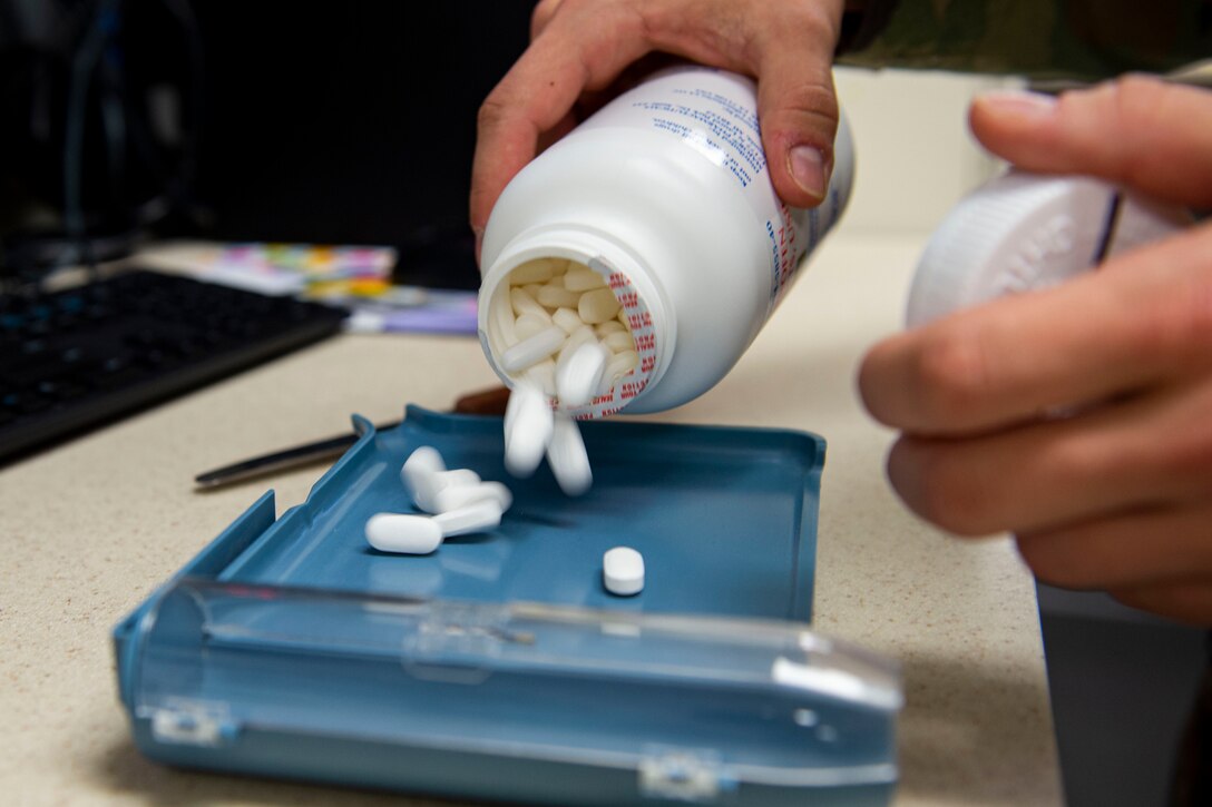 Photo of an Airman pouring prescribed medication.