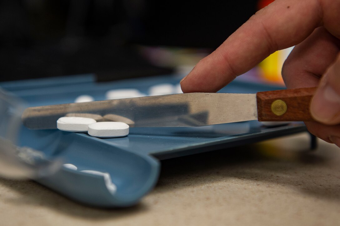 Photo of an Airman counting prescribed medication.