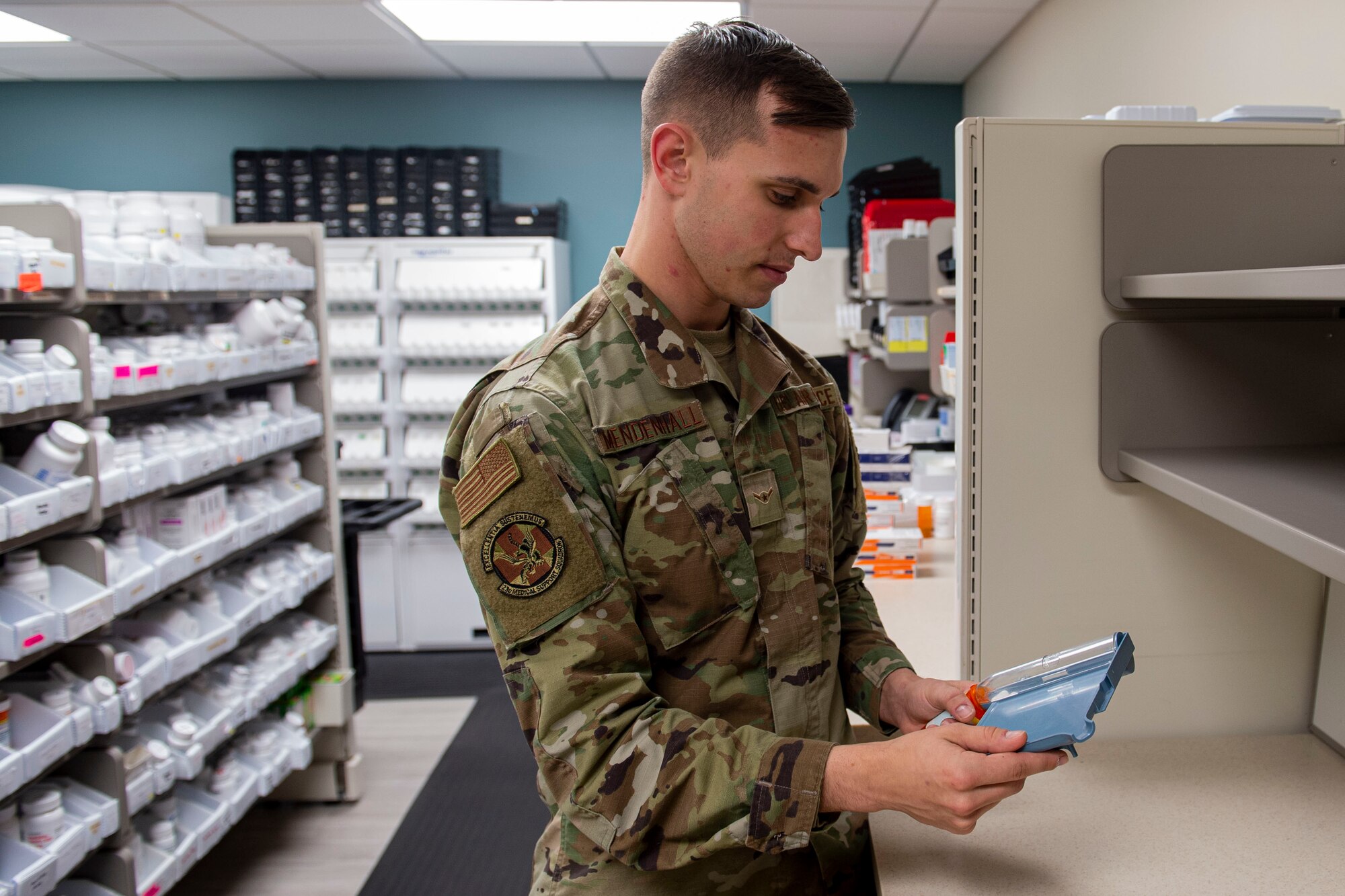 Photo of an Airman pouring prescribed medication into a container.