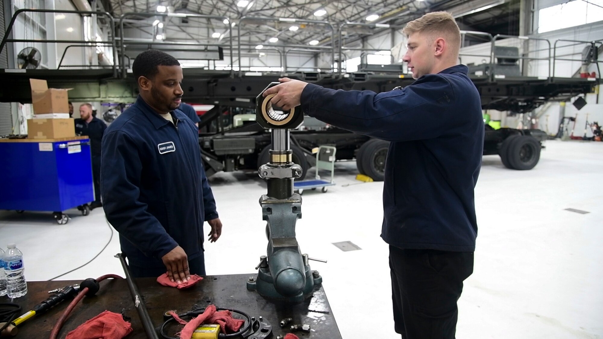 Staff Sgt. Leonard James (left) and Airman 1st Class Mark Chudik, 436th Logistic Readiness Squadron vehicle maintenance, repair a hydraulic component for a k-loader at Dover Air Force Base, Del., Jan. 29, 2020. James lost his fiancé and unborn daughter in a 2010 car accident while attending vehicle maintenance technical training. (U.S. Air Force photo by Tech. Sgt. Laura Beckley).