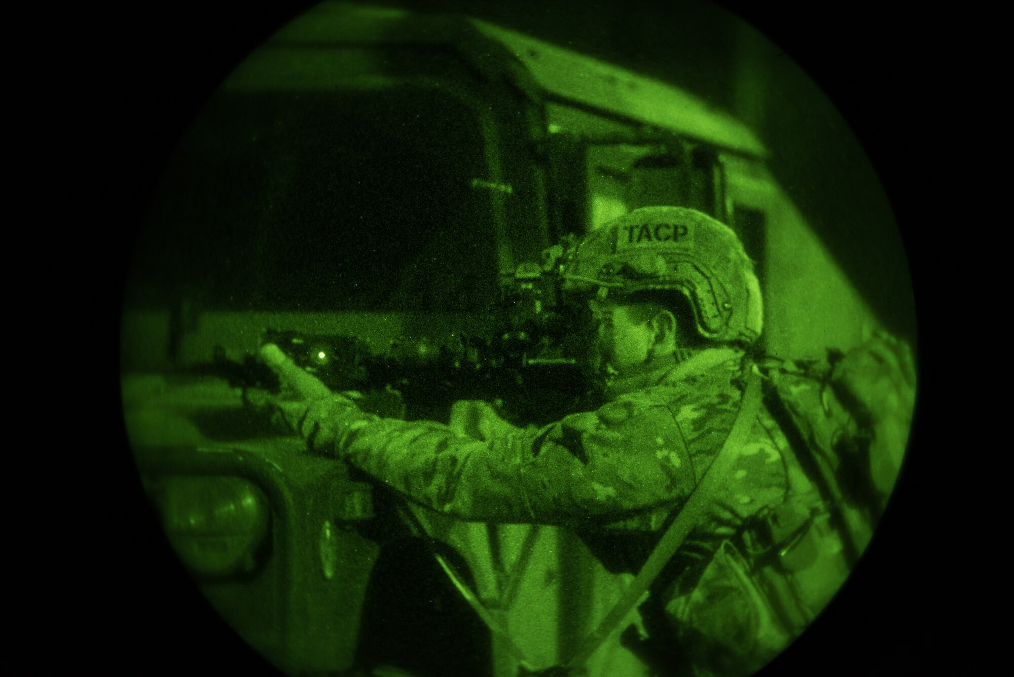 A Tactical Air Control Party specialist from the 148th Air Operations Squadron fires his weapon during night-time training.
