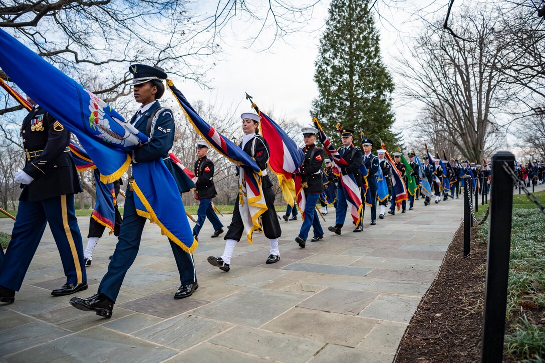 The State and Territorial Flag Cordon marches in a straight line with colorful flags.