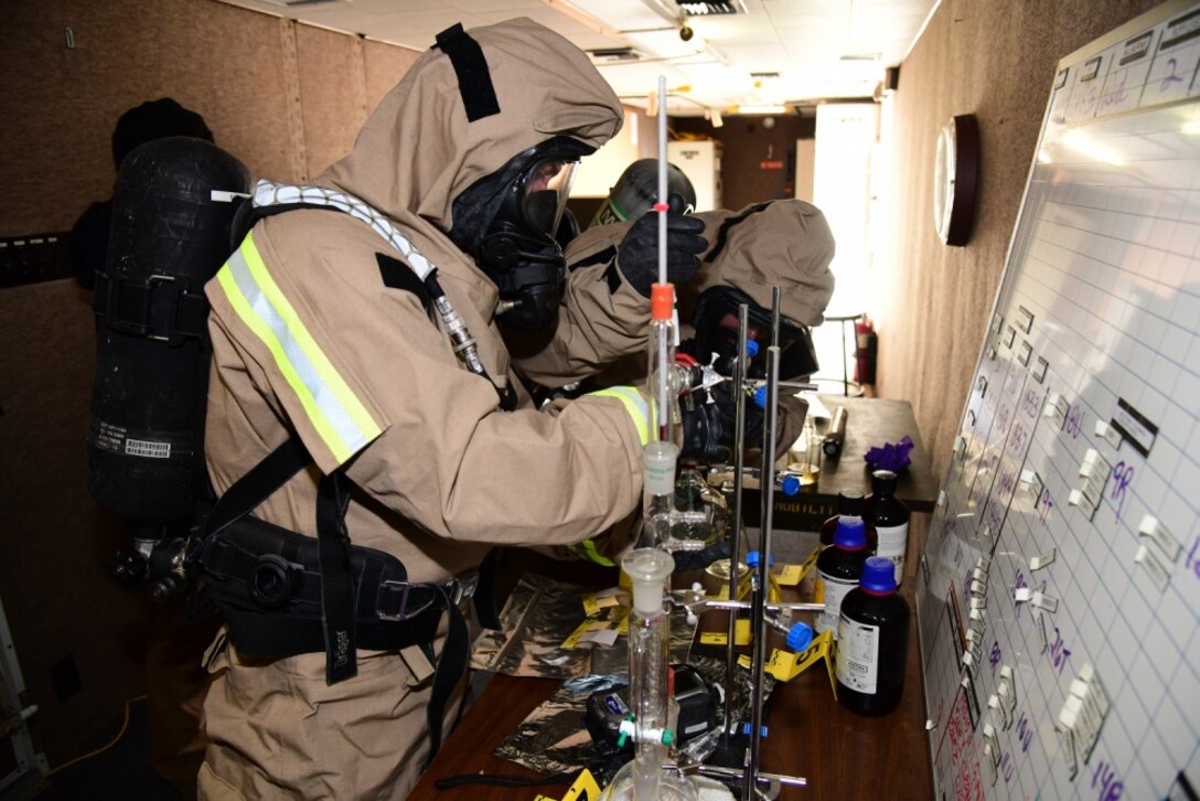 Service members investigate possible contamination.