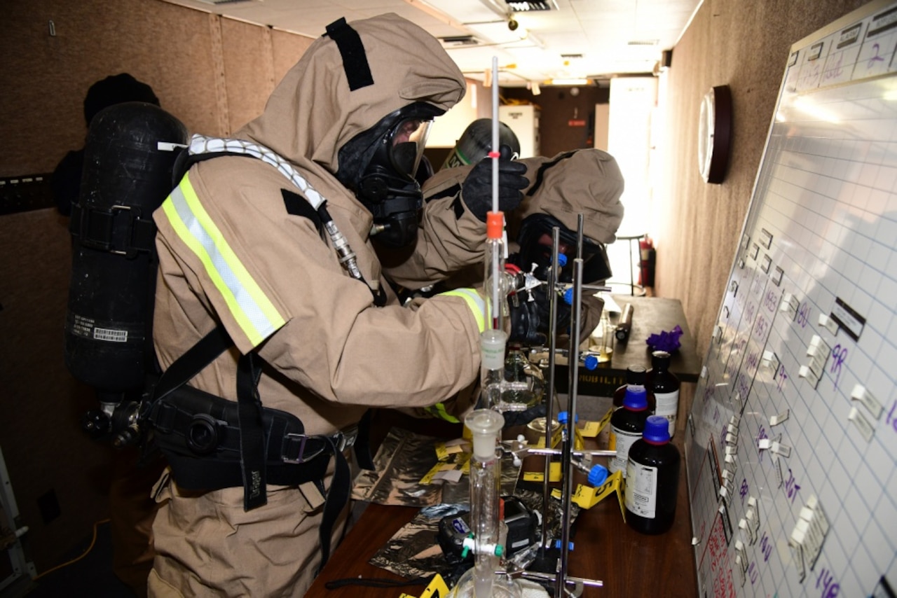 Service members investigate possible contamination.