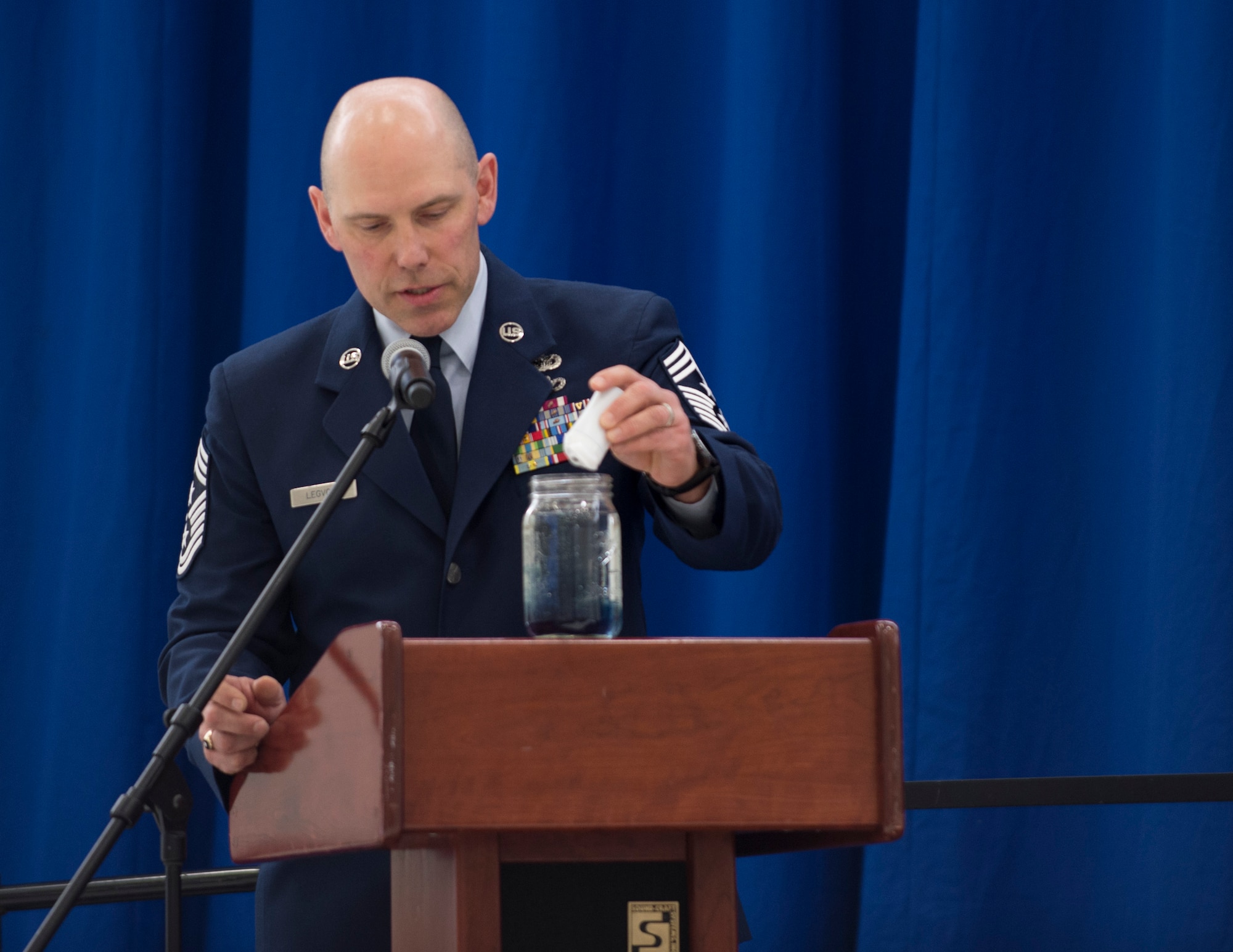 U.S. Air Force Command Chief Master Sgt. Mark Legvold, 133rd Airlift Wing, puts blue drops into a jar of water in St. Paul, Minn., Feb. 9, 2020.
