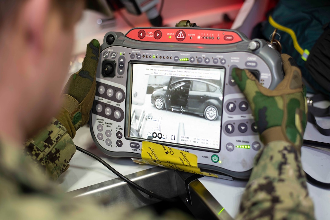 A sailor holds a video monitoring device.
