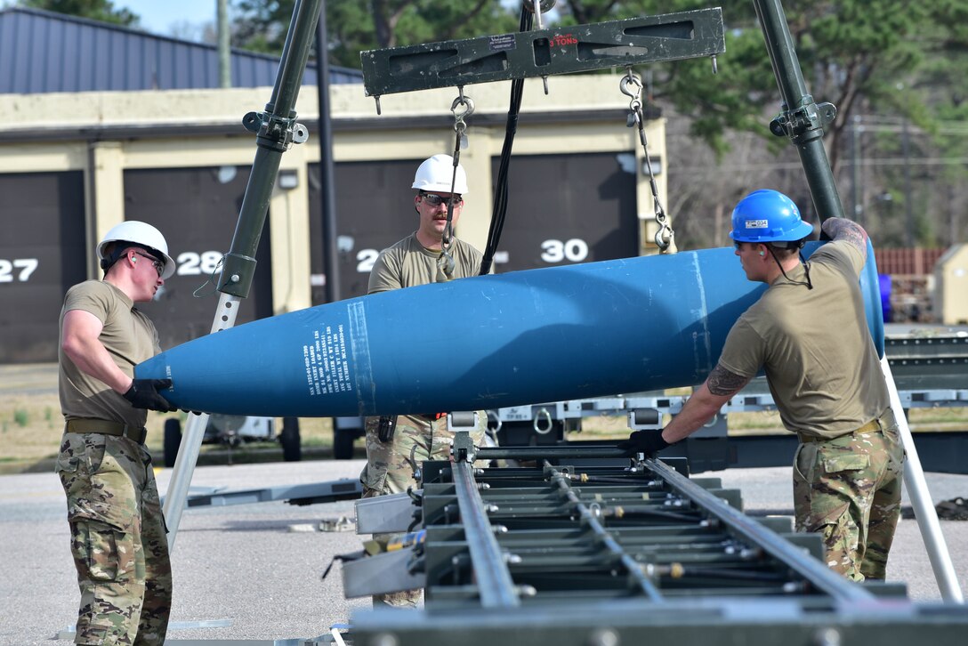 Airmen from the 4th Munitions Squadron set a bomb body onto a munitions assembly conveyer.