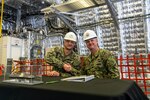 Cmdr. William Dvorak (left) , executive officer, future USS Kansas City (LCS 22) and Cmdr. Kris Netemeyer, littoral combat ship (LCS) program manager's representative Supervisor of Shipbuilding Gulf Coast congratulate each other on the delivery of the 11th Independence variant LCS.