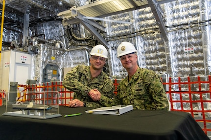 Cmdr. William Dvorak (left) , executive officer, future USS Kansas City (LCS 22) and Cmdr. Kris Netemeyer, littoral combat ship (LCS) program manager's representative Supervisor of Shipbuilding Gulf Coast congratulate each other on the delivery of the 11th Independence variant LCS.