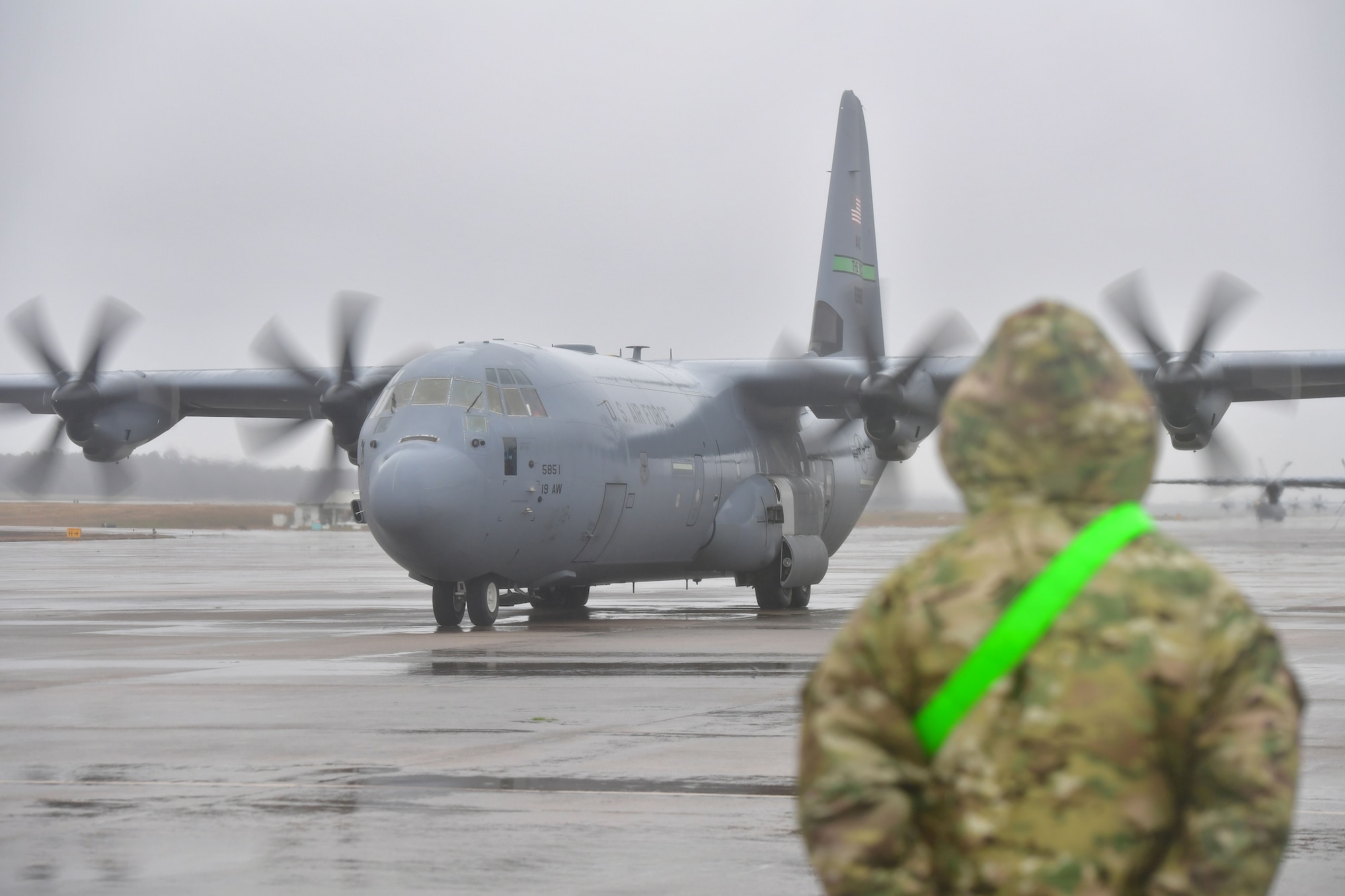 A crew chief from the 19th Aircraft Maintenance Squadron prepares to marshall out a C-130J Super Hercules.