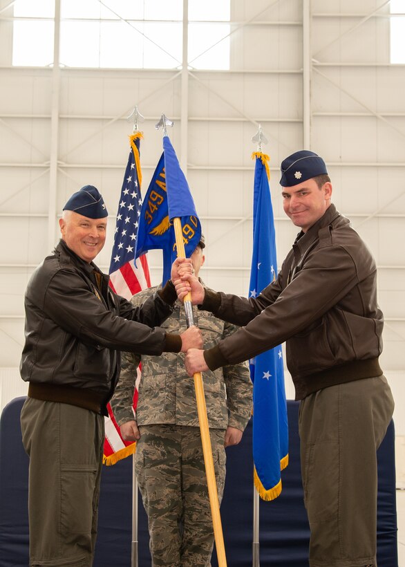 Col. Scott McLaughlin, 349th Air Mobility Wing commander, passes the 349th Operations Group guidon to Lt. Col. Scott Meyer during an assumption of command ceremony Feb. 8, 2020, at Travis Air Force Base, Calif.
