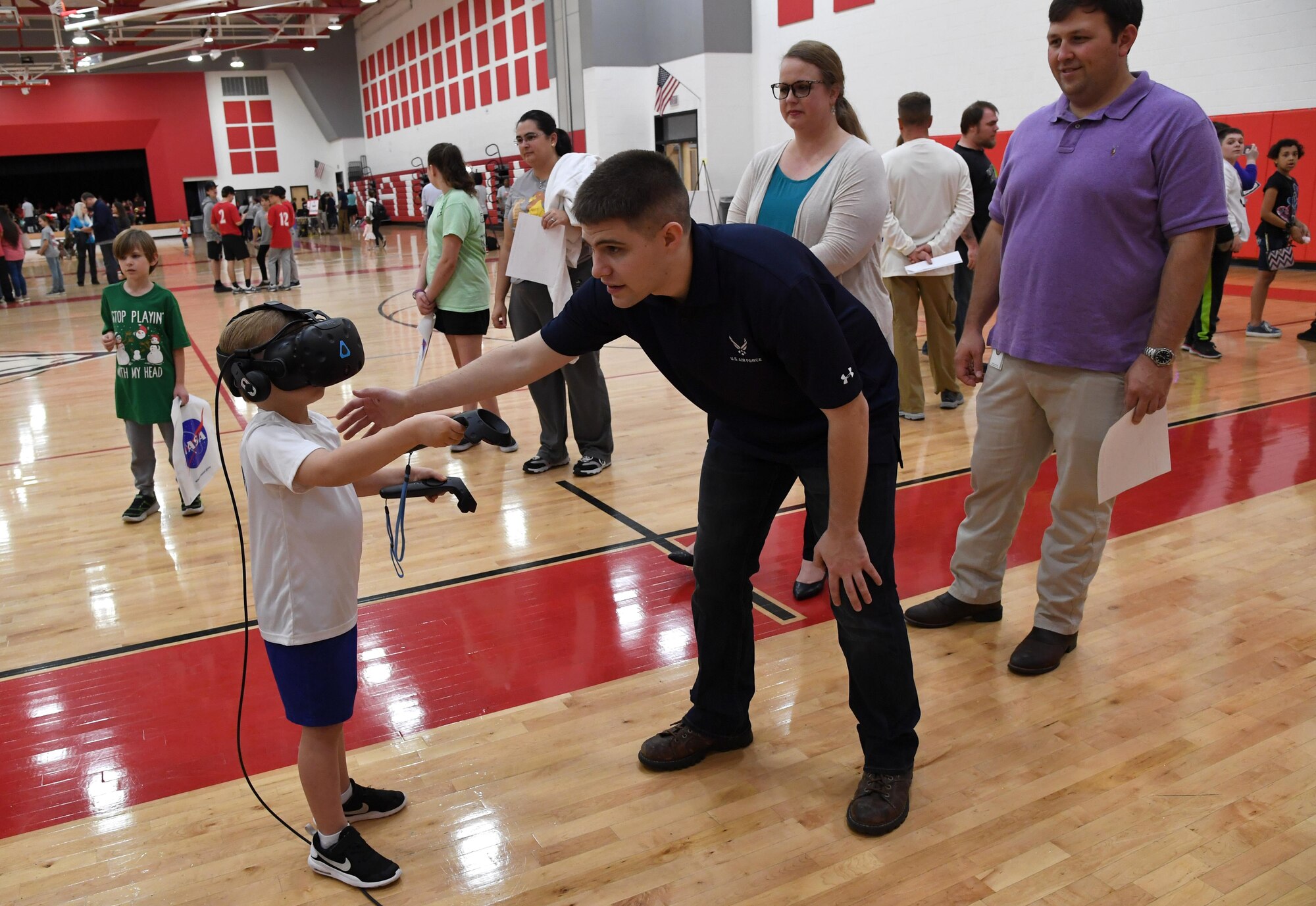 U.S. Air Force Staff Sgt. Brandon McCool, 81st Training Support Squadron interactive multimedia supervisor, provides Jack Carron, North Bay Elementary School student, with a virtual reality demonstration, during the Biloxi Science, Technology, Engineering and Mathematics Night at the Biloxi Junior High School gymnasium, Biloxi, Mississippi, Feb. 11, 2020. The entire Biloxi school district was invited to the event which promoted STEM. Seven career fields from Keesler's 81st Training Wing and the 81st Training Group participated in the event. (U.S. Air Force photo by Kemberly Groue)