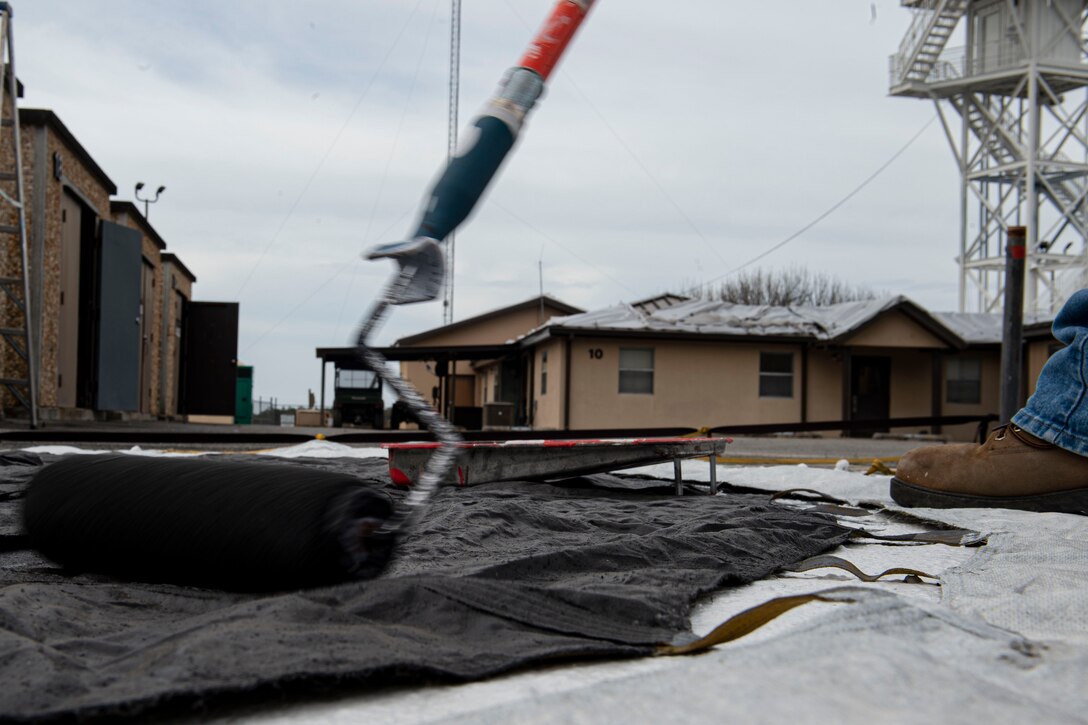 Photo of a range operator painting a drogue parachute.
