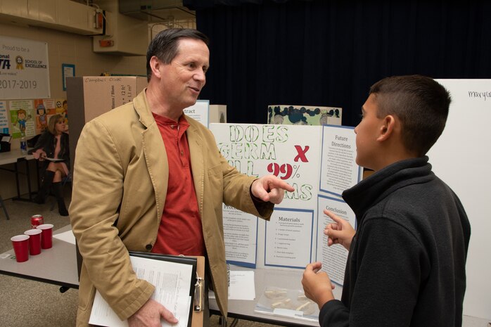 Russ Dunford, who manages strategic plans and integration at Huntsville Center, interviews a sixth-grade student during Monte Sano Elementary School’s science fair in Huntsville, Alabama, Jan. 15, 2020.