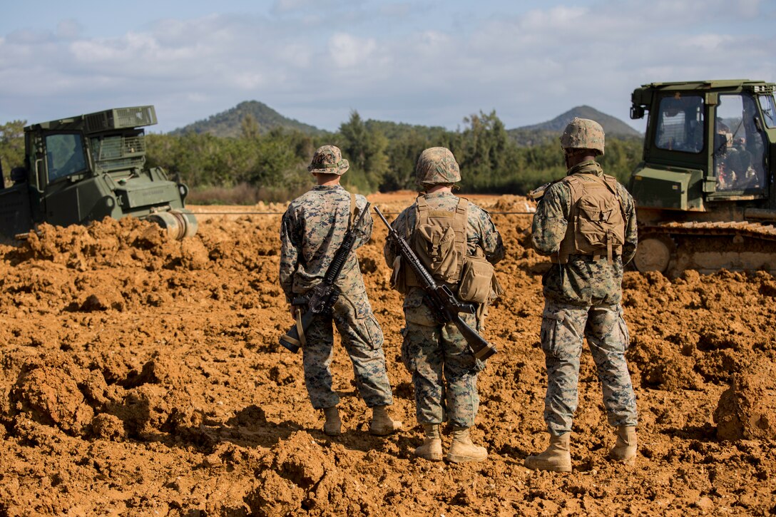 U.S. Marines, with Engineer Support Company, 9th Engineer Support Battalion, 3rd Marine Logistics Group, observe an extraction of a Medium Crawler Tractor at Engineer Training Area, Camp Hansen, Okinawa, Japan, Feb. 6, 2020. The MCT is used to level and excavate top layers of the ground. The Heavy Equipment Operations Platoon conducted a month long field exercise to increase the Marines proficiency in vital mobility combat support operations. (U.S. Marine Corps photo by Lance Cpl. Alpha Hernandez)