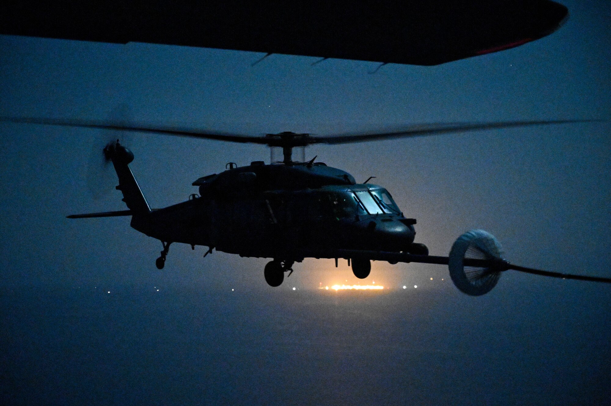 A U.S. Air Force HH-60G Pave Hawk, assigned to the 66th Expeditionary Rescue Squadron deployed to Al Udeid Air Base, Qatar, conducts a helicopter in-air refueling over the Arabian Gulf with a U.S. Air Force HC-130J Combat King II, assigned to the 79th ERQS deployed to Al Udeid AB, Feb. 6, 2020.