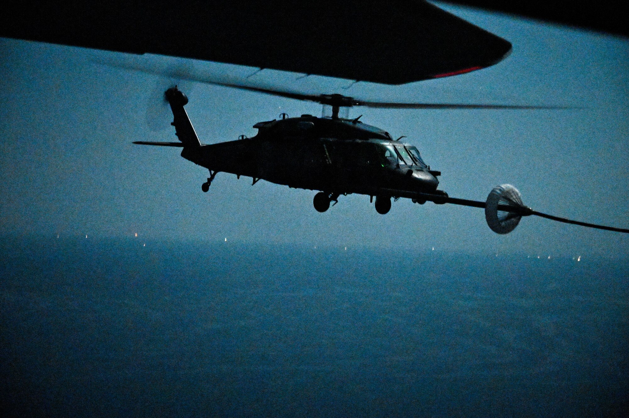 A U.S. Air Force HH-60G Pave Hawk, assigned to the 66th Expeditionary Rescue Squadron deployed to Al Udeid Air Base, Qatar, conducts a helicopter in-air refueling over the Arabian Gulf with a U.S. Air Force HC-130J Combat King II, assigned to the 79th ERQS deployed to Al Udeid AB, Feb. 6, 2020.