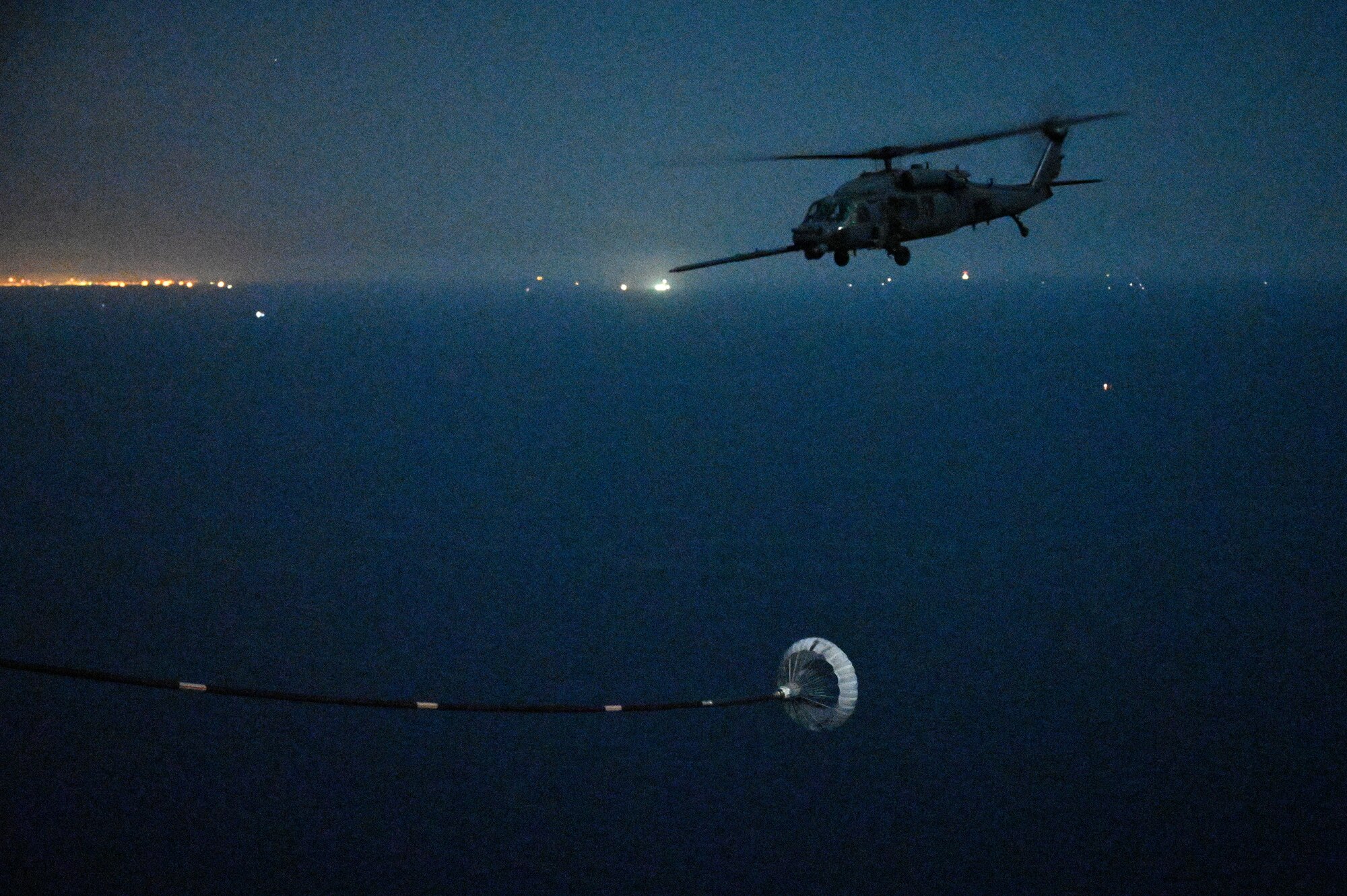 A U.S. Air Force HH-60G Pave Hawk assigned to the 66th Expeditionary Rescue Squadron, deployed to Al Udeid Air Base, Qatar, flies over the Arabian Gulf as it prepares to conduct a helicopter in-air refueling with a U.S. Air Force HC-130J Combat King II assigned to the 79th ERQS, deployed to AL Udeid AB, Feb. 6, 2020.