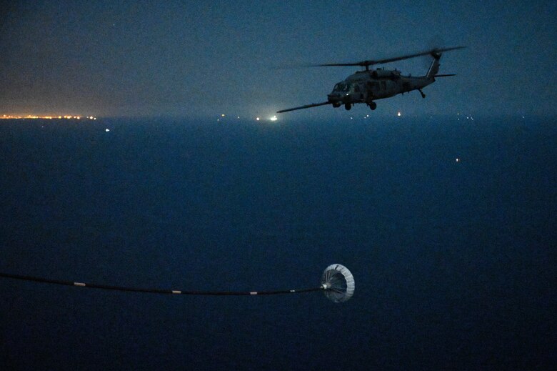 A U.S. Air Force HH-60G Pave Hawk assigned to the 66th Expeditionary Rescue Squadron, deployed to Al Udeid Air Base, Qatar, flies over the Arabian Gulf as it prepares to conduct a helicopter in-air refueling with a U.S. Air Force HC-130J Combat King II assigned to the 79th ERQS, deployed to AL Udeid AB, Feb. 6, 2020.