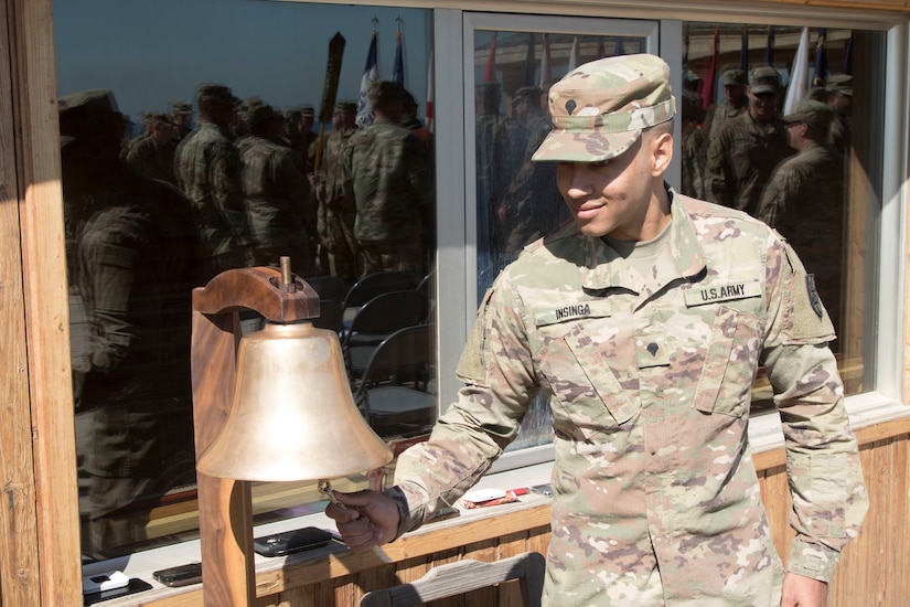 Spc. Cameron Insinga, watercraft operator, 492nd Theater Harbormaster Operations Detachment (THOD), rings the bell eight times to signify mission complete during the 492nd THOD's end of mission ceremony at Kuwait Naval Base, Feb. 13, 2020.