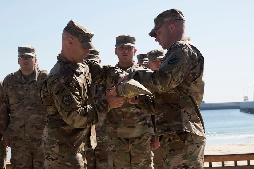 Chief Warrant Officer 4 Nicholas Laferte, commander, and Sgt. 1st Class Benjamin McGalliard, first sergeant, 492nd Theater Harbormaster Operations Detachment (THOD), case their unit colors during the 492nd THOD's end of mission ceremony at Kuwait Naval Base, Feb. 13, 2020.