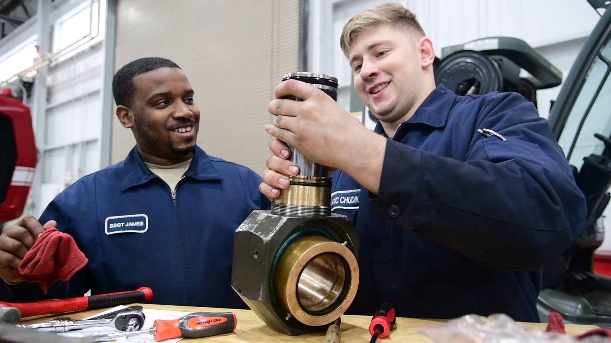 Staff Sgt. Leonard James and Airman First Class Mark Chudik, 436th Logistic Readiness Squadron Vehicle Maintenance, repair a hydraulic component for a k-loader at Dover Air Force Base, Del., on January 29, 2020. James lost his fiancé and unborn daughter in a 2010 car accident while attending vehicle maintenance technical training. (U.S. Air Force photo by Tech. Sgt. Laura Beckley).
