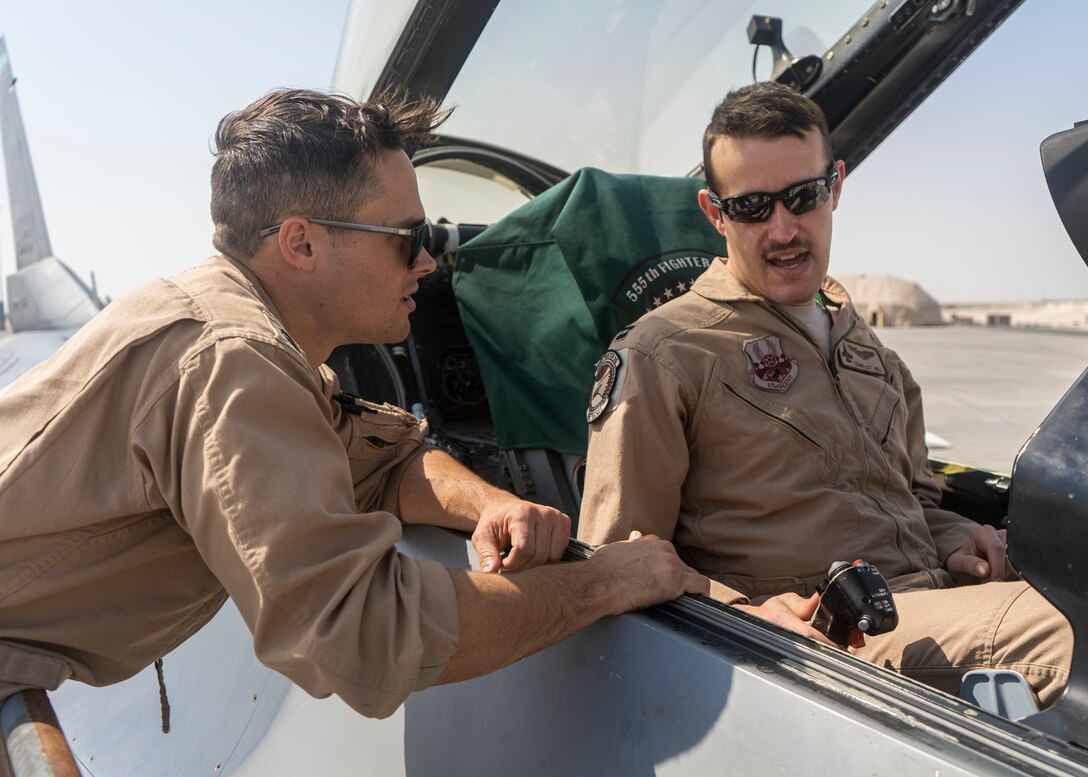 U.S. Navy EA-18G Growler pilot, Lt. Andrew Jaffer, talks to U.S. Air Force F-16 Fighting Falcon pilot Capt. James Hill about the aircraft controls at Al Udeid Air Base, Qatar on Feb. 8, 2020. The 379th Expeditionary Operations Group held a mission orientation day to give service members a more in-depth look at how AUAB supports the U.S. Air Forces Central Command mission. (U.S. Air Force photo by Senior Airman Olivia Grooms)