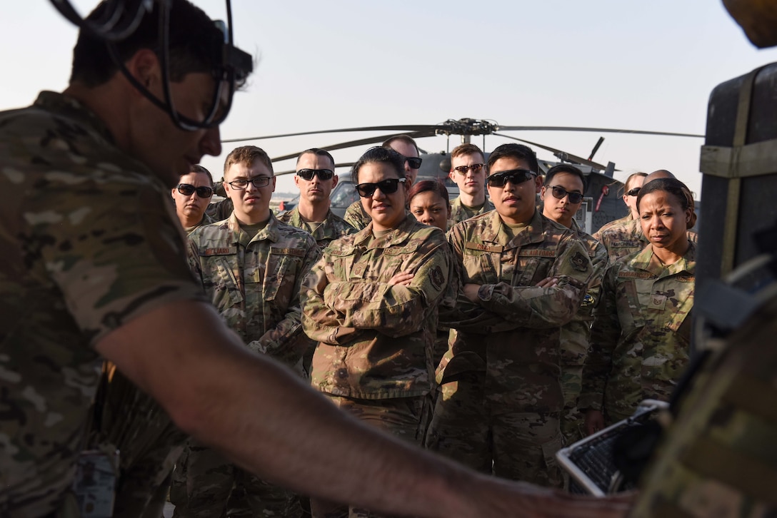 Service members gather around an HH-60 Pave Hawk pilot as he explains the aircraft during a mission orientation brief at Al Udeid Air Base, Qatar on Feb. 8, 2020. The 379th Expeditionary Operations Group held the mission orientation day to give service members a more in-depth look at how AUAB supports the U.S. Air Forces Central Command mission. (U.S. Air Force photo by Senior Airman Shay Stuart)
