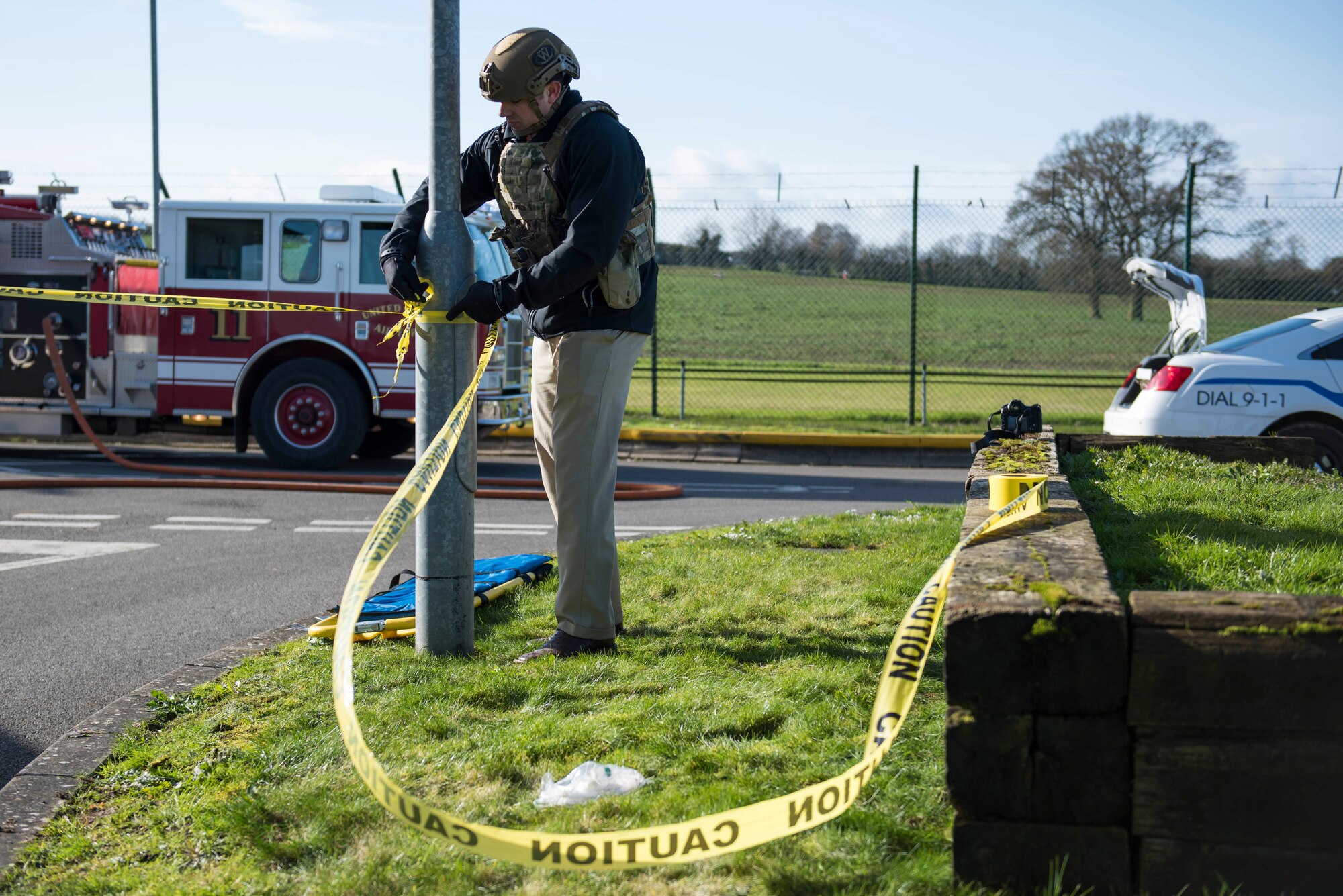 U.S. Air Force Staff Sgt. Kirk Clark, 422nd Security Forces Squadron investigator, ties caution tape around simulated car bomb location during the 501st Combat Support Wing Readiness Exercise 20-01 at RAF Croughton, England, Feb. 12, 2020. The exercise tested the wing’s preparedness and response capabilities to an emergency situation. (U.S. Air Force photo by Airman 1st Class Jennifer Zima)