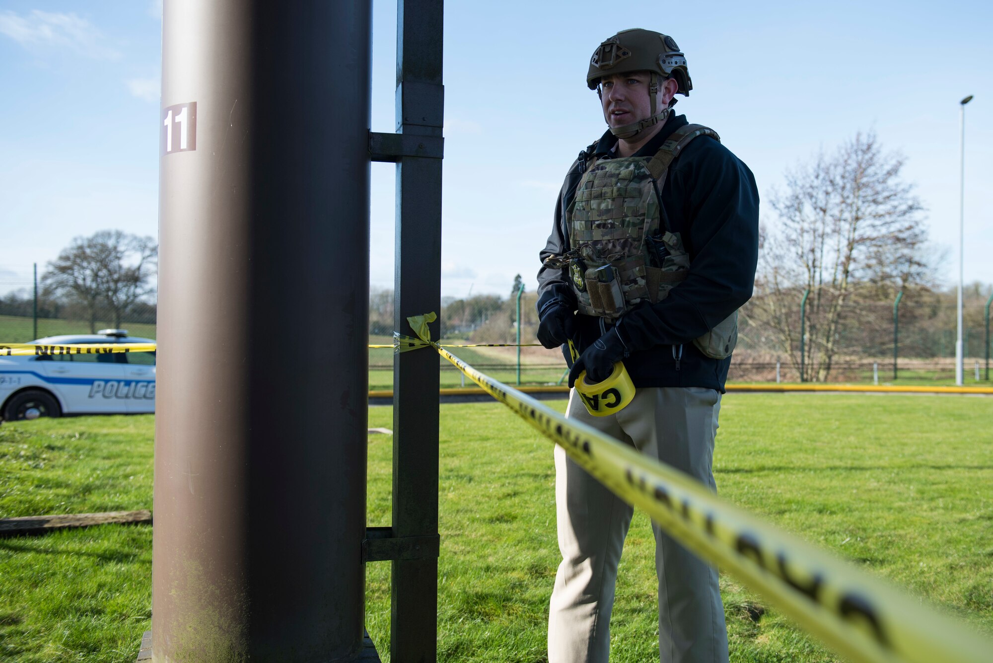 U.S. Air Force Staff Sgt. Kirk Clark, 422nd Security Forces Squadron investigator, ties caution tape around simulated car bomb location during the 501st Combat Support Wing Readiness Exercise 20-01 at RAF Croughton, England, Feb. 12, 2020. The exercise tested the wing’s preparedness and response capabilities to an emergency situation. (U.S. Air Force photo by Airman 1st Class Jennifer Zima)