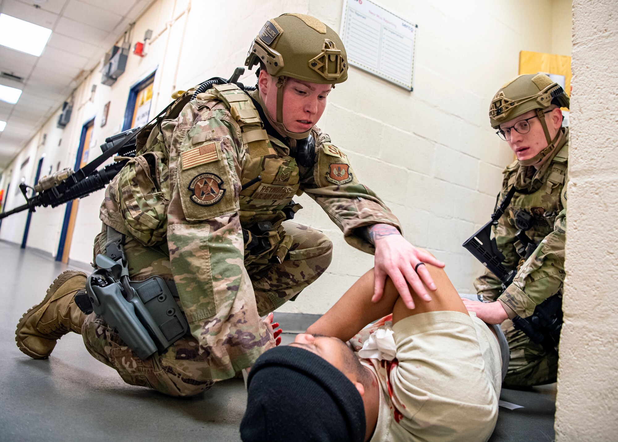 Staff Sgt. Chelsea Reynolds, (left) 423d Security Forces Squadron flight sergeant, and Senior Airman Wyatt White, (right), tend to a simulated victim during a readiness exercise, at RAF Molesworth, England, Feb. 11, 2020. The exercise tested the wing’s preparedness and response capabilities to an emergency situation. (U.S. Air Force photo by Senior Airman Eugene Oliver)