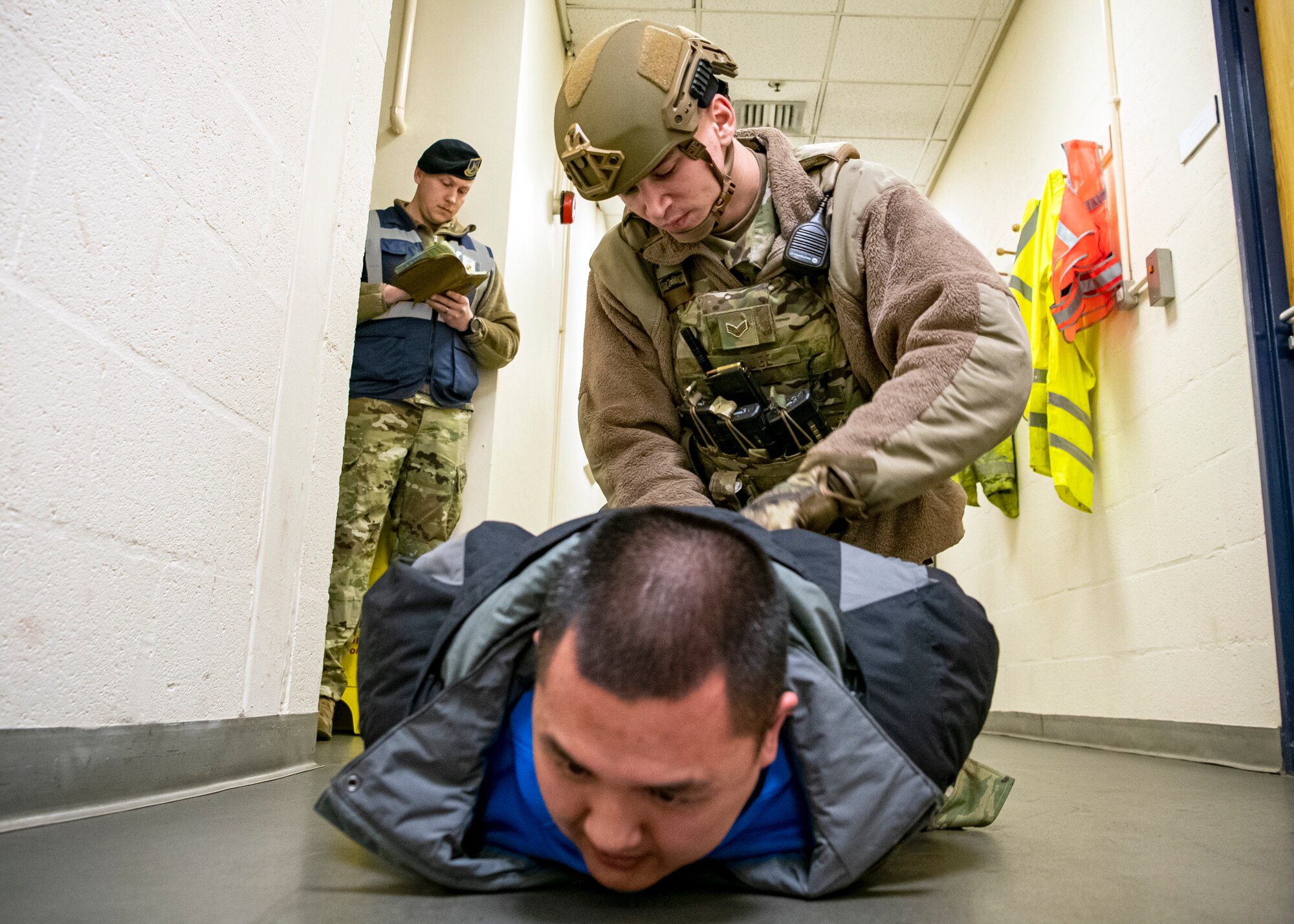 Senior Airman Dustin Kluge, (center), 423d Security Forces Squadron Emergency center controller, apprehends a simulated suspect during a readiness exercise, at RAF Molesworth, England, Feb. 11, 2020. The exercise tested the wing’s preparedness and response capabilities to an emergency situation. (U.S. Air Force photo by Senior Airman Eugene Oliver)