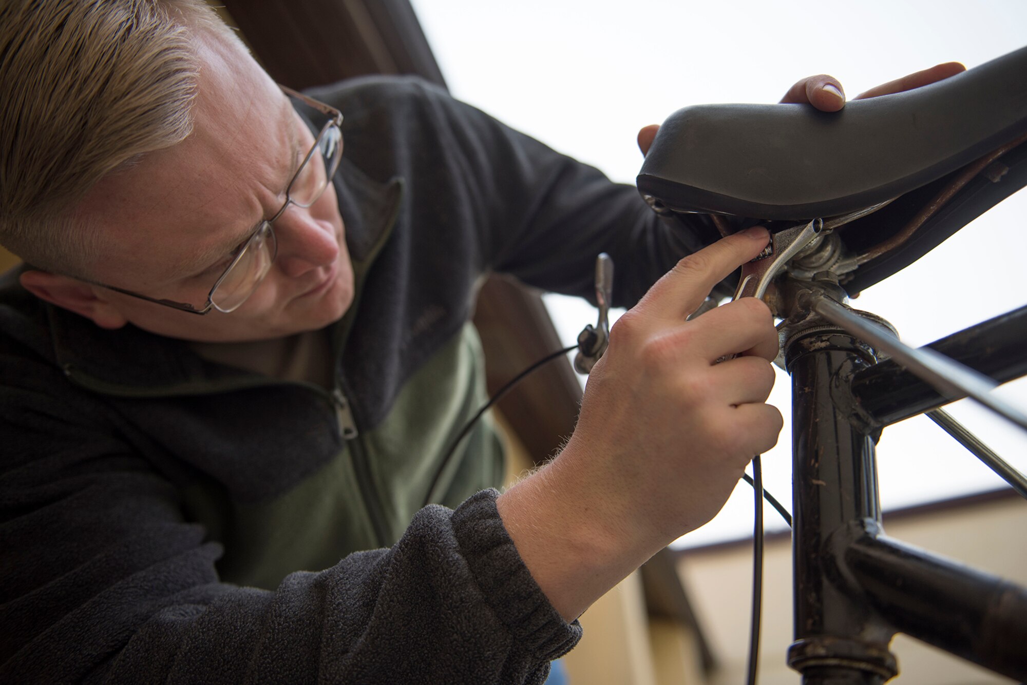 Staff Sgt. Eric Mann, 39th Air Base Wing Public Affairs broadcast journalist, tightens the seat of his bike Feb. 12, 2020, at Incirlik Air Base, Turkey.