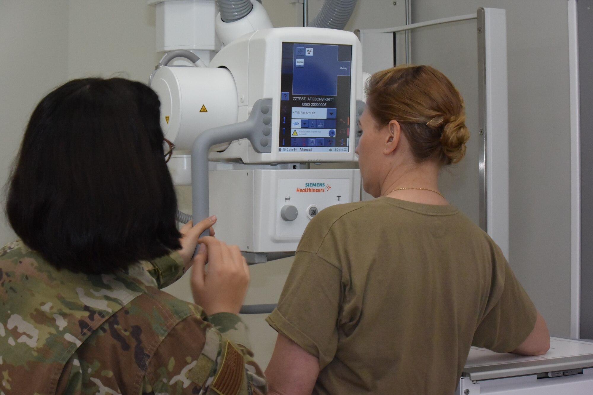 two women next to an x-ray machine