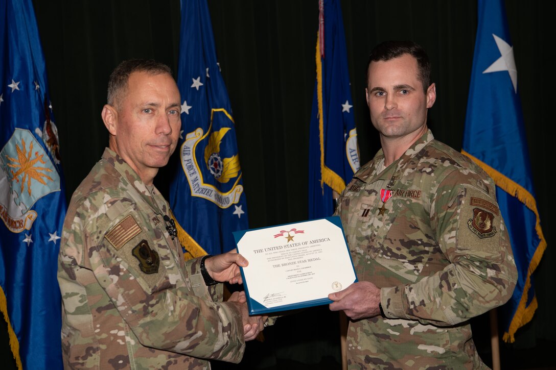Maj. Gen. Tom Wilcox, Air Force Installation and Mission Support Center commander, stand with Capt. Shane Lockridge after awarding the Bronze Star to him at a commander’s call Feb. 13.