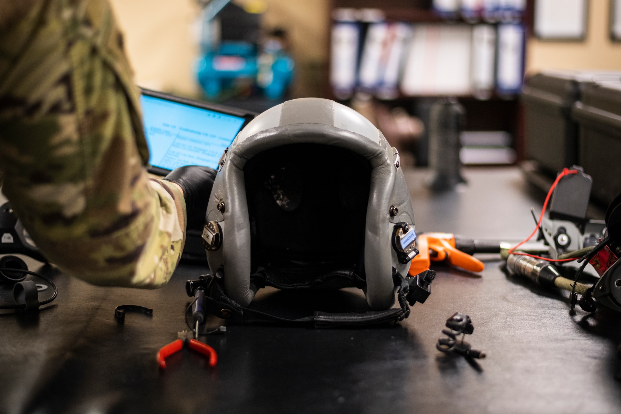 A photo of an Airman inspecting a helmet