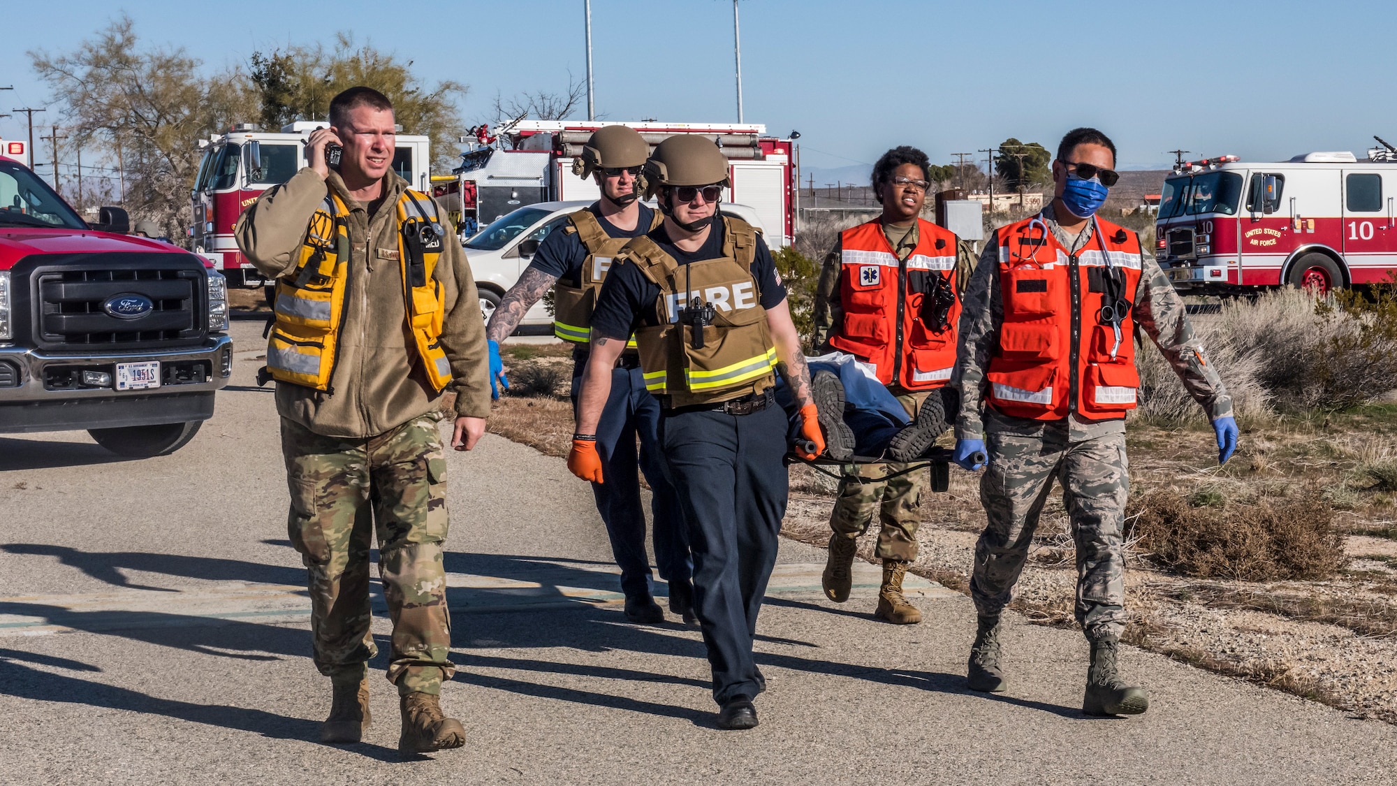 Fire and medical crews carry a victim towards a Los Angeles County Fire Department helicopter during an active shooter exercise at Edwards Air Force Base, California, Feb. 11. The victims were transported to the Antelope Valley Hospital in nearby Lancaster, California. (Air Force photo by Richard Gonzales)