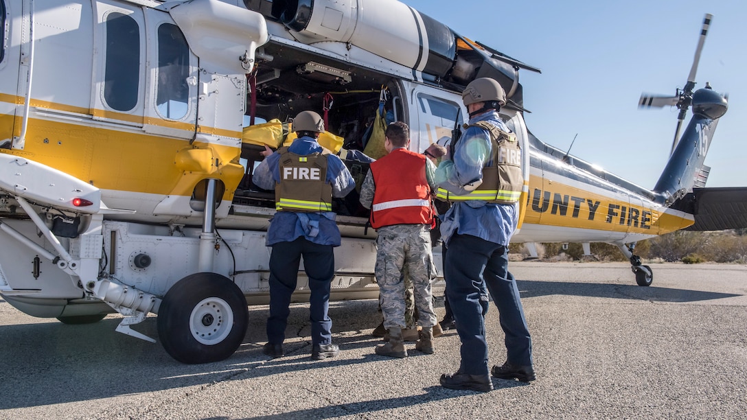 Fire and medical response crews load a victim onboard a Los Angeles County Fire Department helicopter during an active shooter exercise at Edwards Air Force Base, California, Feb. 11. The victims were transported to the Antelope Valley Hospital in nearby Lancaster, California. (Air Force photo by Richard Gonzales)