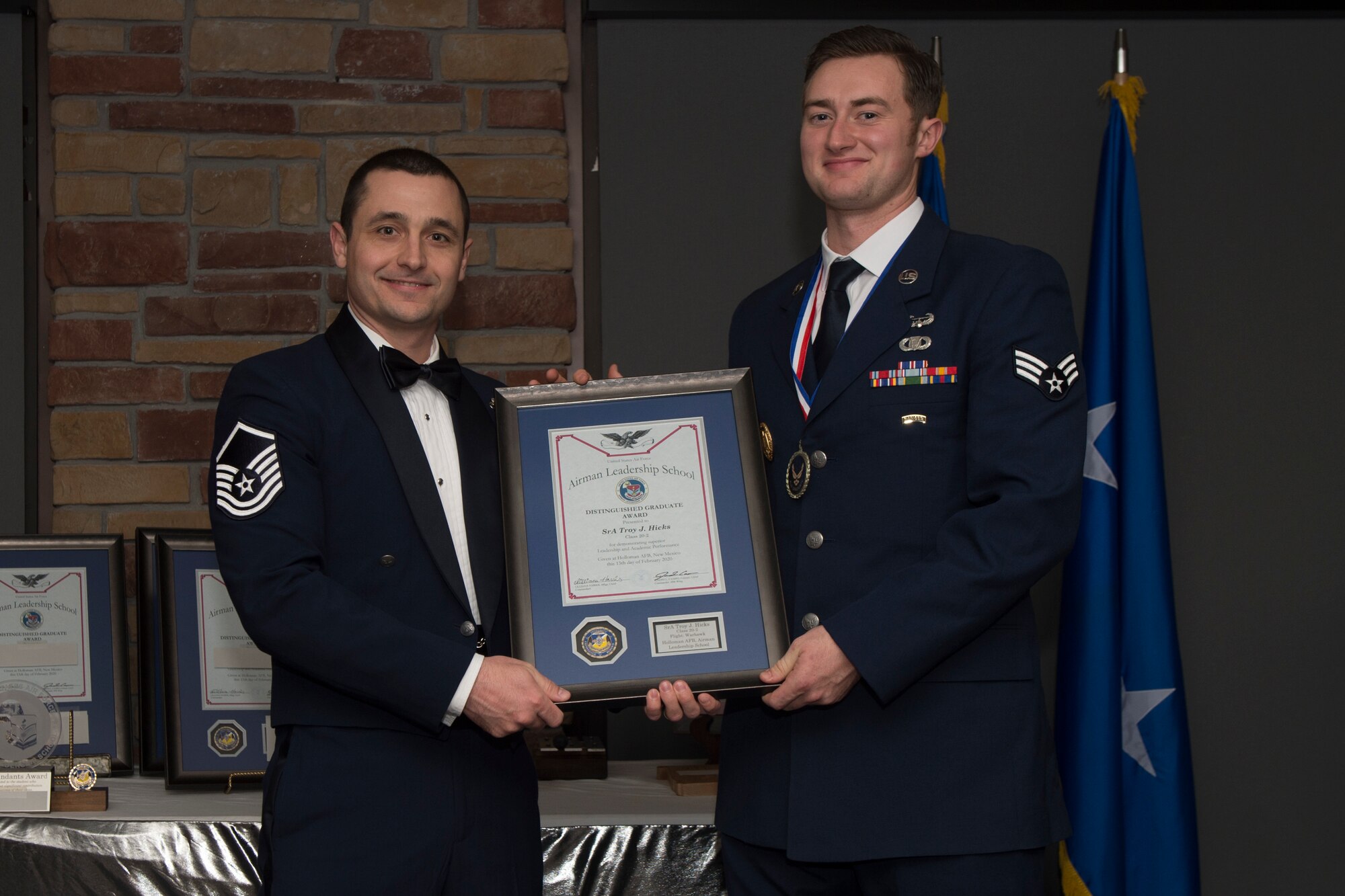 Senior Airman Troy Hicks, Airman Leadership School graduate, accepts the distinguished graduate award during the graduation of ALS class 20-2, Feb.13, 2020, on Holloman Air Force Base, N.M. The distinguished graduate award is presented to the top ten-percent of graduates for their performance in academic evaluations and demonstration of leadership. (U.S. Air Force photo by Airman 1st Class Kristin Weathersby).