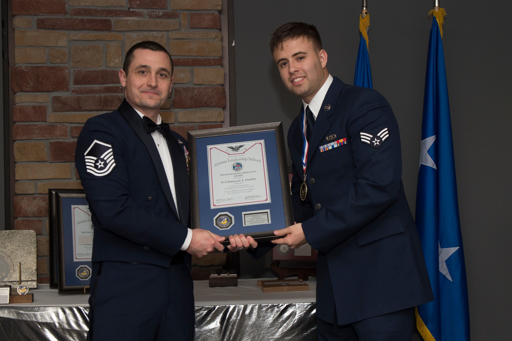 Senior Airman Desmond Padilla, Airman Leadership School graduate, accepts the distinguished graduate award during the graduation of ALS class 20-2, Feb.13, 2020, on Holloman Air Force Base, N.M. The distinguished graduate award is presented to the top ten-percent of graduates for their performance in academic evaluations and demonstration of leadership. (U.S. Air Force photo by Airman 1st Class Kristin Weathersby).