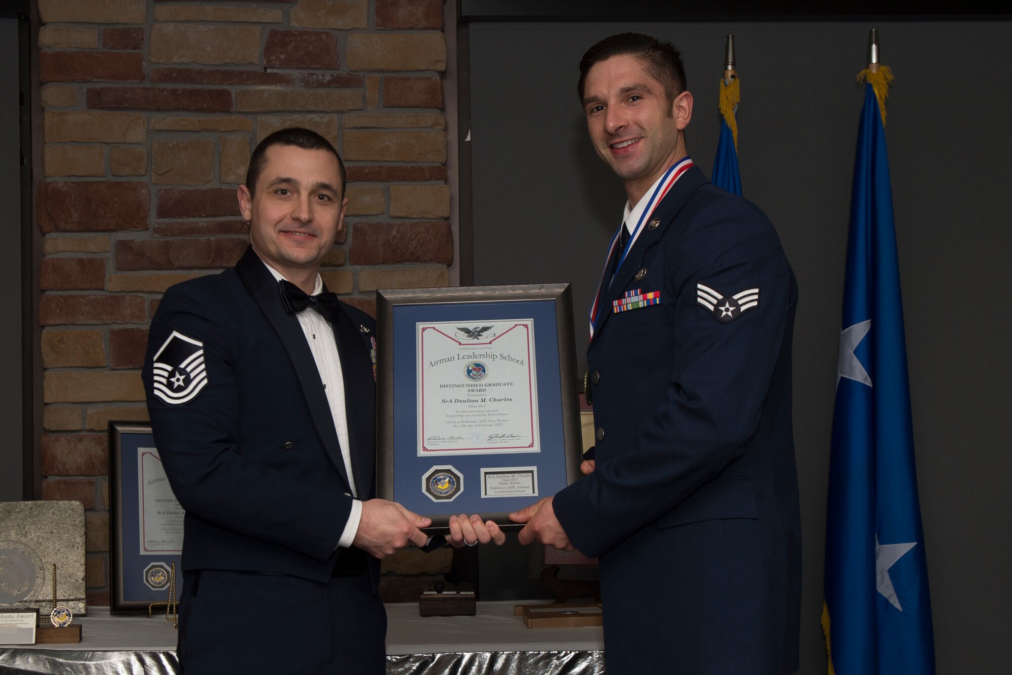 Senior Airman Daulton Charles, Airman Leadership School graduate, accepts the distinguished graduate award during the graduation of ALS class 20-2, February 13, 2020, on Holloman Air Force Base, N.M. The distinguished graduate award is presented to the top ten-percent of graduates for their performance in academic evaluations and demonstration of leadership. (U.S. Air Force photo by Airman 1st Class Kristin Weathersby).