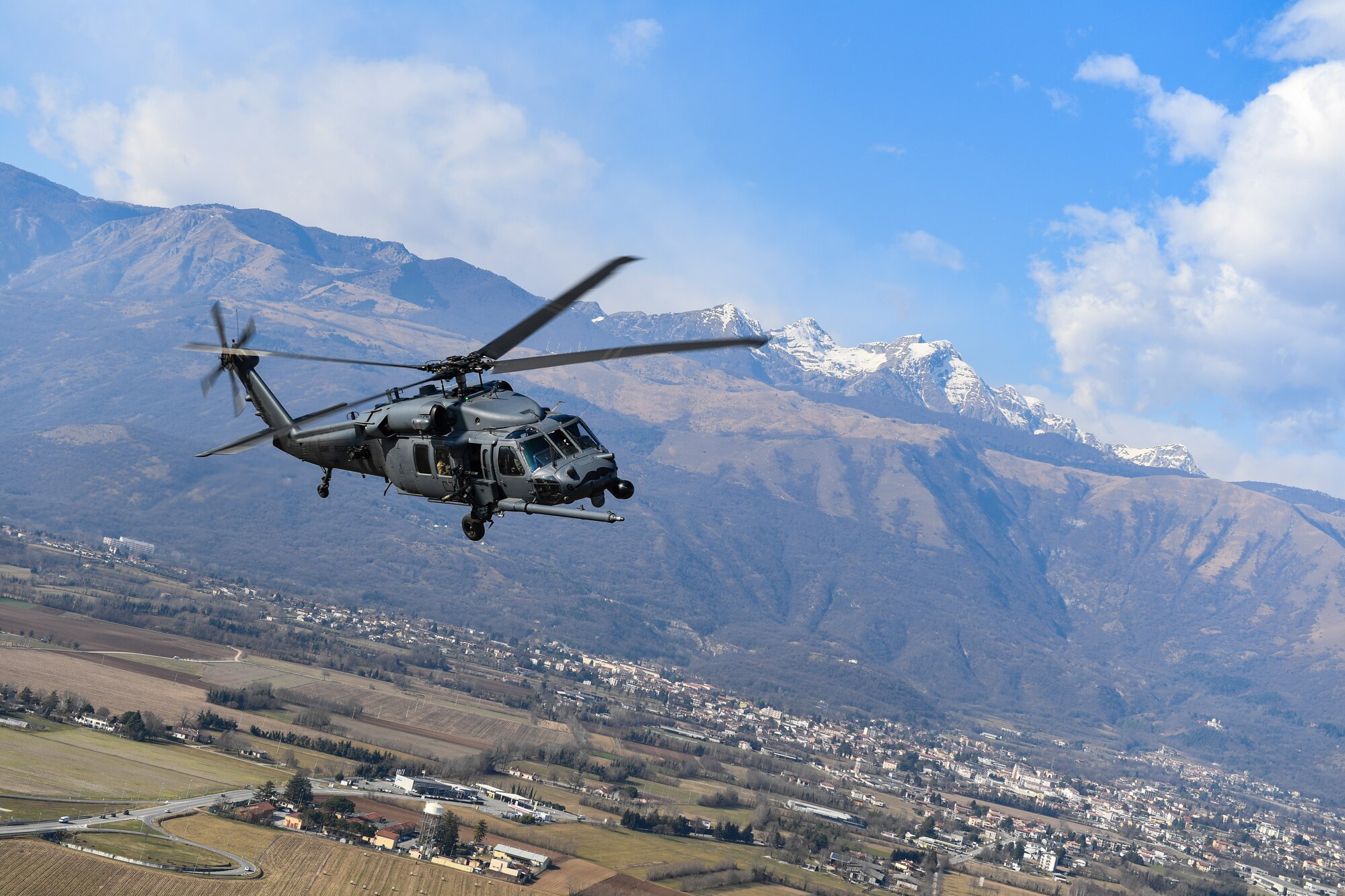 An HH-60G Pave Hawk helicopter flies over Aviano Air Base