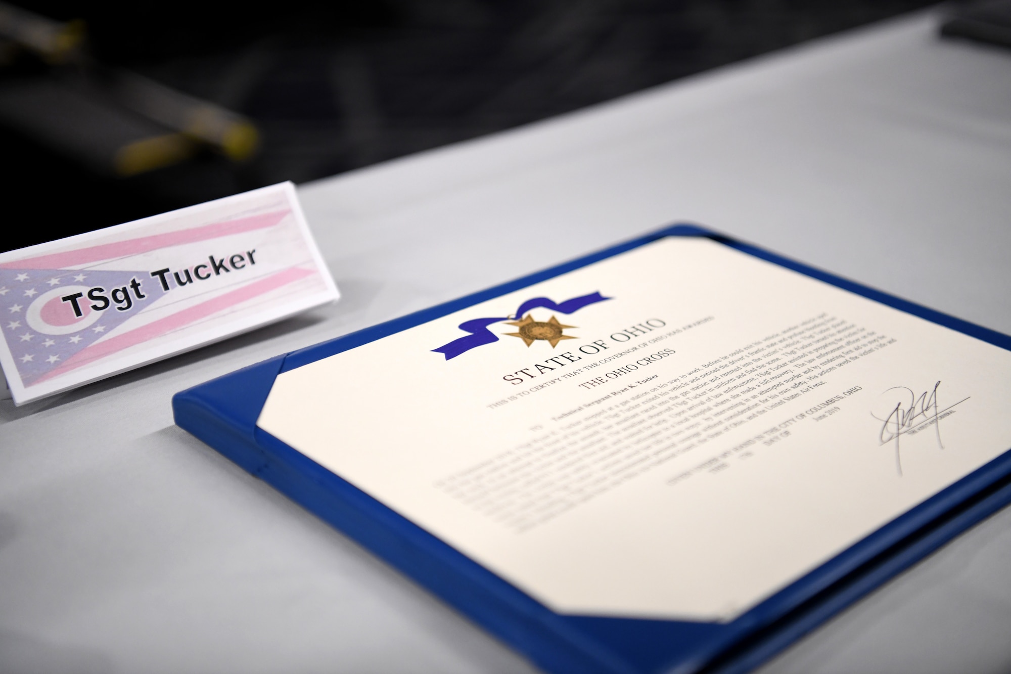 The citation for the Ohio Cross sits on a table after Ohio’s Lt. Governor Jon Husted awarded the Ohio Cross to U.S. Air Force Master Sgt. Ryan Tucker during the Ohio National Guard’s Joint Senior Leaders Conference Feb. 14, 2020 in Columbus, Ohio. The Ohio Cross is awarded to any member of the state military forces who distinguishes themselves by gallantry and intrepidity at the risk of his/her life. (U.S. Air Force photo by Tech. Sgt. Shane Hughes)