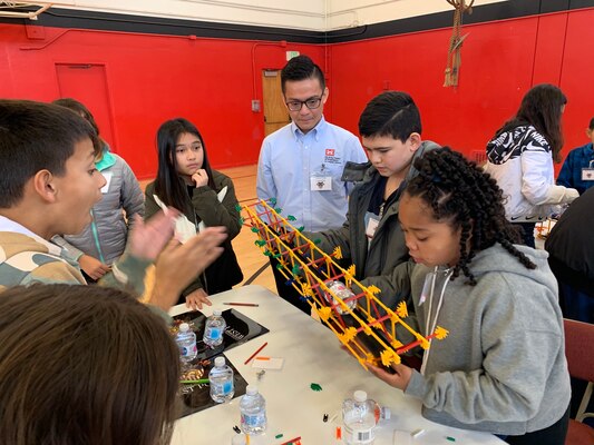 U.S. Army Corps of Engineers Los Angeles District USACE Structural Civil Engineer Lenard Lee Tran encourages students to design and build bridges during a West Point Academy Science, Technology, Engineering, and Mathematics event at Stephen M. White Middle School in Carson, California.