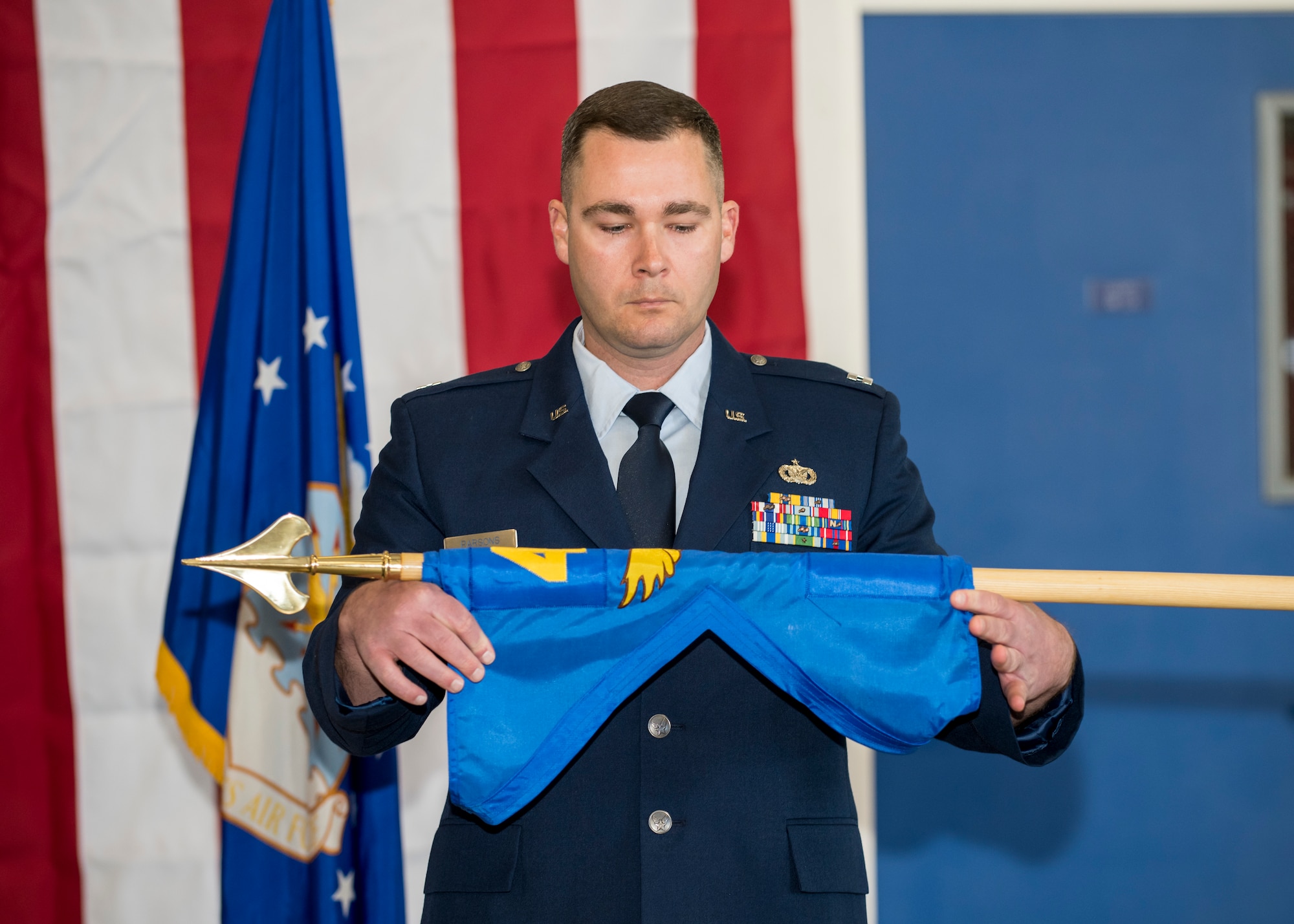 Capt. Daniel Parsons, 412th Security Forces Squadron Det. 1 Commander, unfurls his unit’s guidon during an activation and assumption of command ceremony at the 412th Test Wing Operation Location Plant 42 in Palmdale, California, Feb. 13. (Air Force photo by Giancarlo Casem)