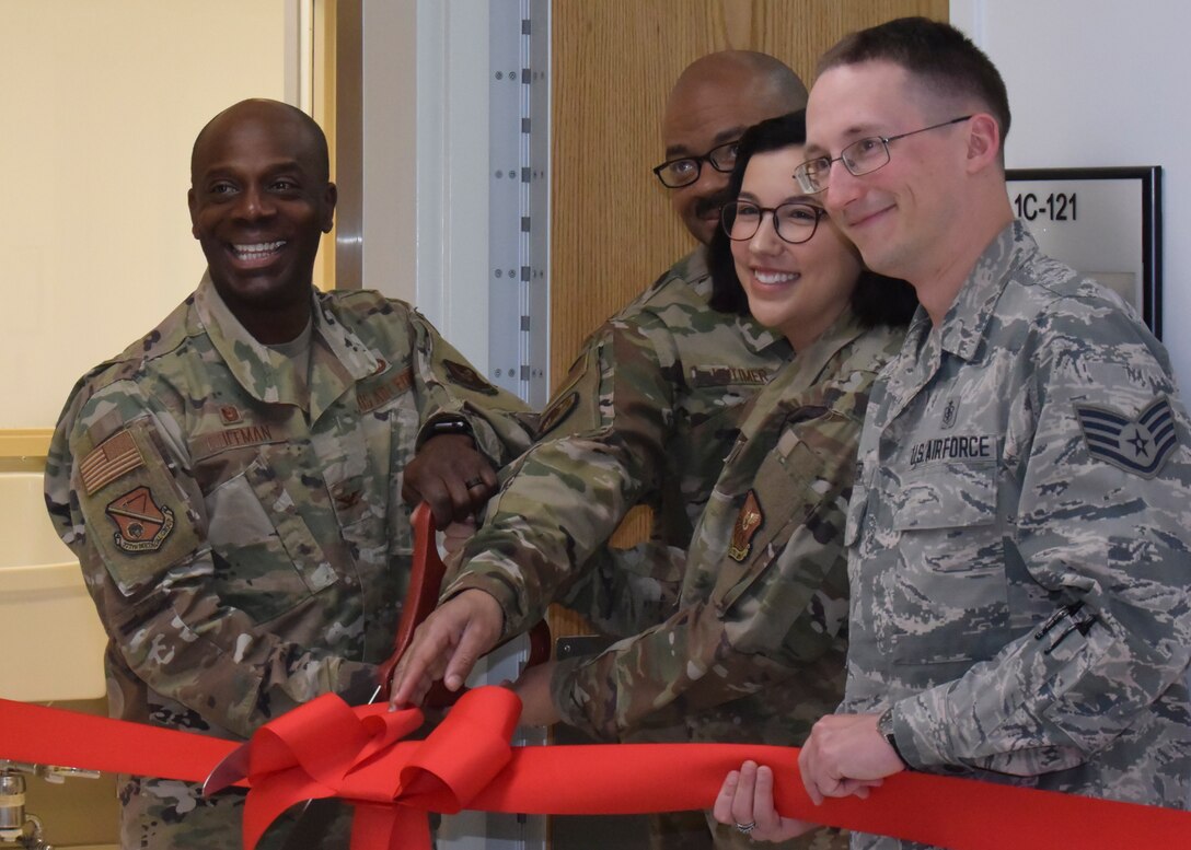 people cutting a red ribbon