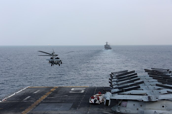 A U.S. Navy MH-60S Sea Hawk helicopter departs from the amphibious assault ship USS Bataan (LHD 5). The Bataan Amphibious Ready Group, with embarked 26th Marine Expeditionary Unit, is deployed to the U.S. 5th Fleet area of operations in support of naval operations to ensure maritime stability and security in the Central Region, connecting the Mediterranean and the Pacific through the western Indian Ocean and three strategic choke points. (U.S. Marine Corps photo by Cpl. Nathan Reyes/Released)