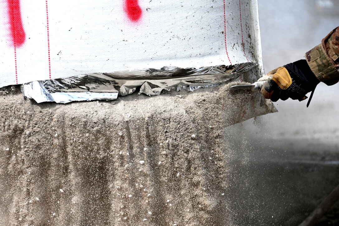 Photo of concrete bag being cut open.