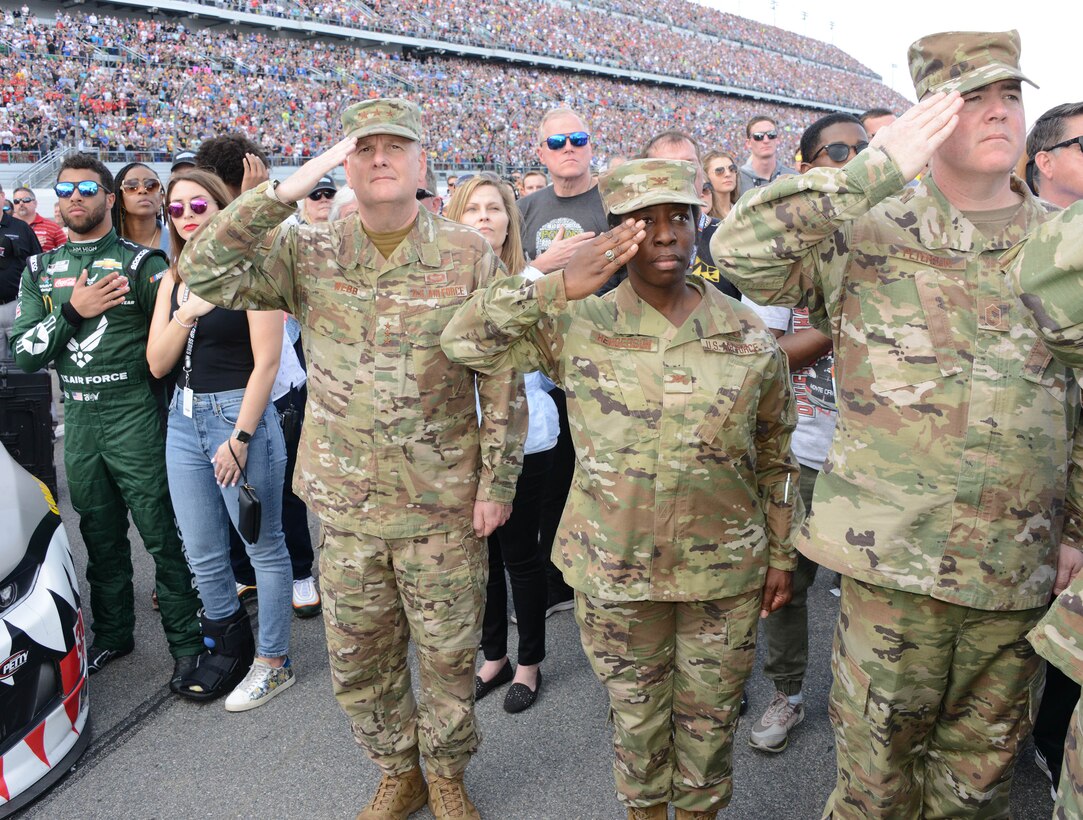 Bubba Wallace, driver of Richard Petty Motersports No. 43 car, Lt. Gen. Brad Webb, Air Education and Training commander and members of Air Force Recruiting Service salute the flag during the National Anthem at the 2020 Daytona 500.