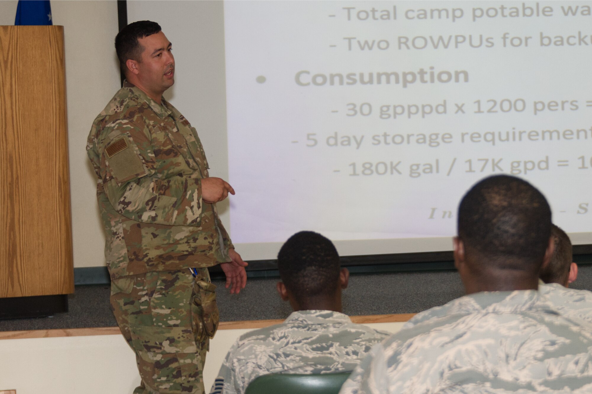 Photo of Airman delivering a briefing to crowd.